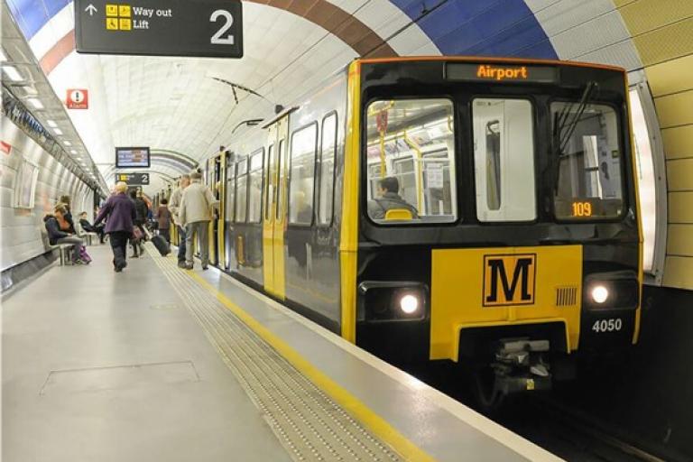 Photo of a metro at an underground station with people getting off.