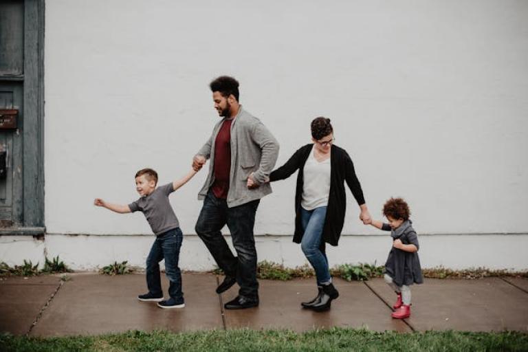 A happy family holding hands and walking