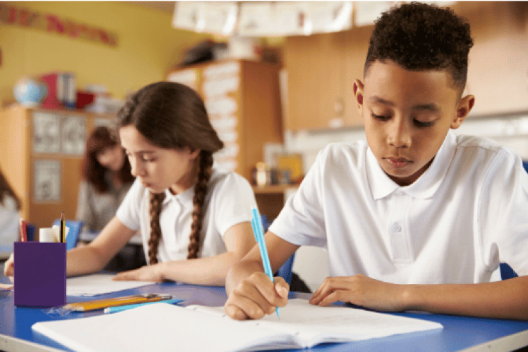Children at school writing in their notebooks