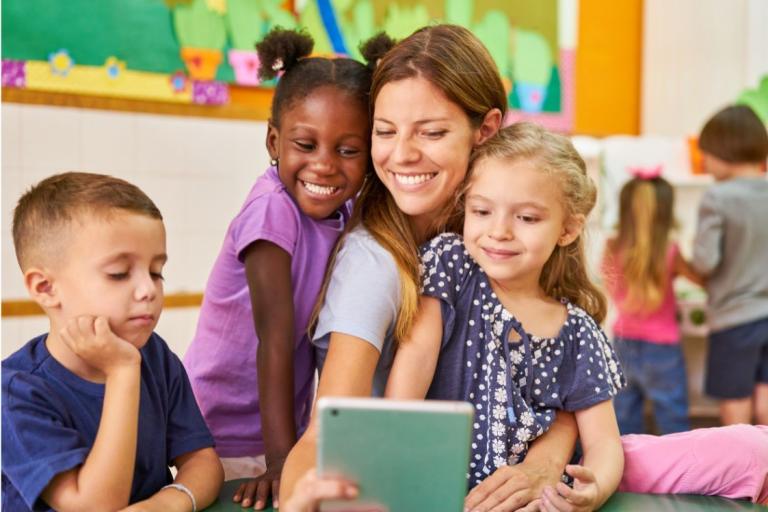 Children with a teacher smiling 
