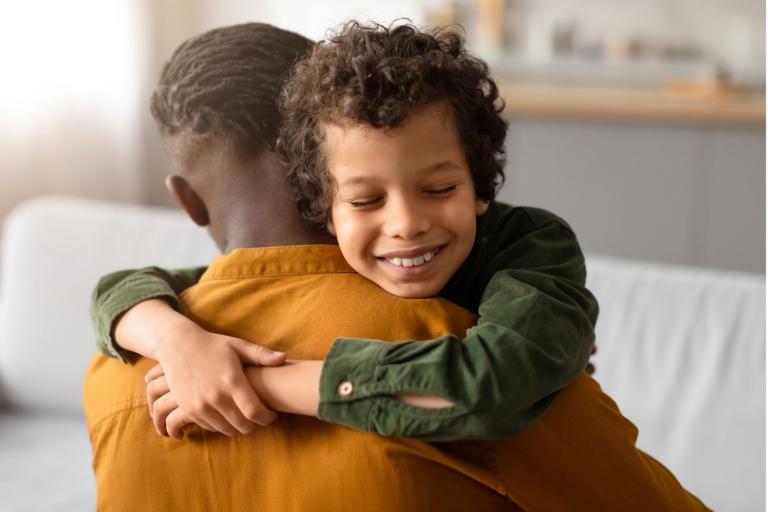 Boy hugging man