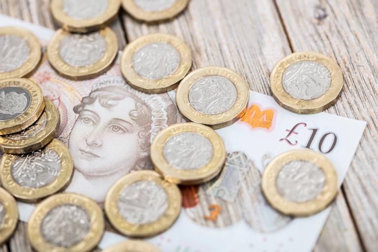 Image shows £10 note and several pounds coins