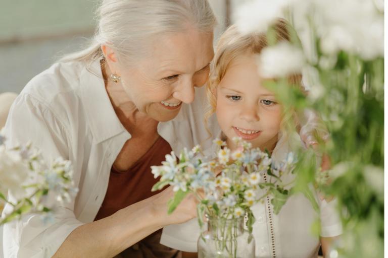 Grandmother with granddaughter looking at flowers