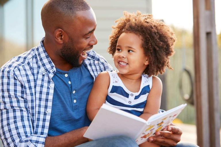 Father figure reading with young girl