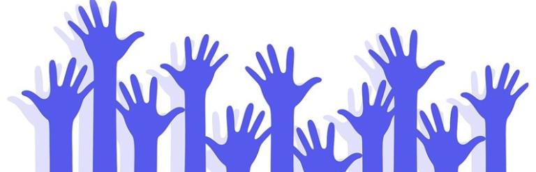 Many silhouetted hands reaching up